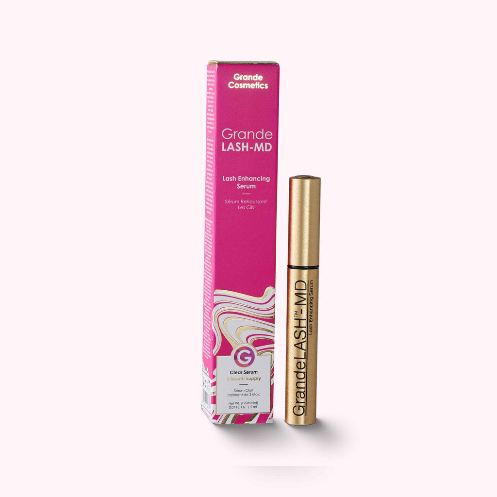 Pink Box next to gold tube with LASH ENHANCING SERUM with blend of vitamins, antioxidants, and amino acids. No parabens. No artificial color or fragrance. 0.1 fl oz / 3 ml